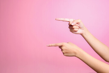 Two hands points to something with index finger over pink background, cut out