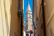 Stroll along narrow urban street that meanders its way towards magnificent St. George Parish Church. Old town of charming coastal town of Piran, Slovenian Istria, Slovenia, Europe. Sightseeing