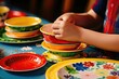 Stacking colorful ceramic bowls on a vibrant tablecloth.