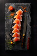 A display of Japanese sashimi sushi prepared by a seafood restaurant chef on a black background