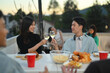 © Prathankarnpap - Happy Asian male and female friends toasting champagne at a rooftop party.