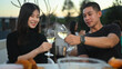 © Prathankarnpap - Shot of young Asian couple toasting champagne and enjoying lunch together at a rooftop restaurant.