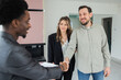 © ABCreative - Seal deal with african american dark skinned realtor by hadshake professional real estate agent selling the dream home to young just married couple happy wife and husband becoming homeowners.