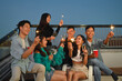 © Prathankarnpap - Group of young adult best friends having fun lighting sparklers during rooftop party.