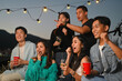 © Prathankarnpap - Group of millennial people friends chilling and enjoying hangout time together at rooftop party.