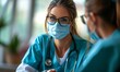 © Jan - Doctor in a face mask attentively listening to a patient during a medical consultation.