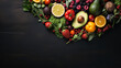 heart shape by various vegetables and fruits on black stone background