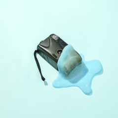 Wall Mural - Creative minimalist layout. Camera with slime on a blue background. Surreal summer idea. Conceptual pop