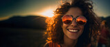 Fototapeta  - portrait of a laughing young Caucasian woman in fashionable round mirror sunglasses with curly hair, copy space, girl stands with her back to the sun, Generated AI