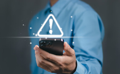 businessman or user, programmer, developer using smart phone with triangle caution warning sign for 