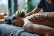 © agnes - Therapist applying massage oil on a female patient's back in a serene spa