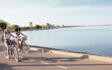 Wall Mural - Teenagers of different nationalities and appearance on bicycles ride along a city street