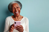 Fototapeta  - An elderly black woman smiling and laughing with her phone against a colored background. ai generative
