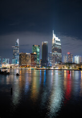 Wall Mural - Ho Chi Minh City skyline and the Saigon River. Amazing colorful night view of skyscraper and other modern buildings at downtown. Travel concept