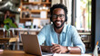 © Studio Nova - Man with a beard and glasses, wearing headphones, smiling at the camera, seated in a cafe or an office with a laptop in front of him