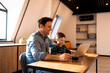 © Dasha Petrenko - Brunette father and son using a laptop while father drinking breakfast coffee