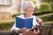 © auremar - attractive mature woman reading a book in the park