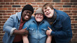 copy space, stockphoto, high quality photo, young man with down syndrome posing with other friends. Accepting people with disiblilties or mental disadvantaged people. Disability awareness theme.