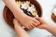 © InfiniteFlow - Woman indulges in blissful foot massage at luxurious spa salon while masseur give reflexology therapy in gentle day light ambiance resort or hotel foot spa. Quiescent