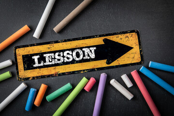 Wall Mural - Lesson. Direction arrow with text on a dark chalkboard background