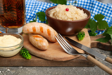 Bavarian sausages with sauerkraut and mayonnaise on wooden board