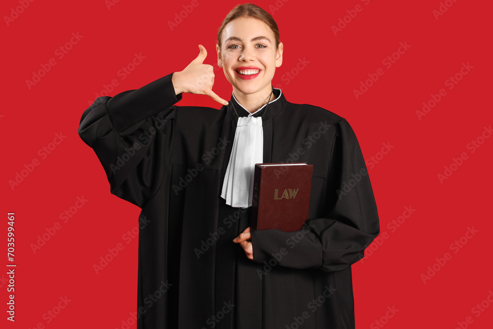 Young judge with law book showing "call me" gesture on red background