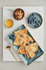 Wall Mural - Thin pancakes, homemade crepes on a plate with blueberry