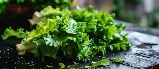 Green lettuce chopped and placed on a black table.