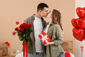 Canvas Print - Young couple with bouquet of roses and gift for Valentine's day at home