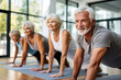 Elderly people do stretching in the gym.