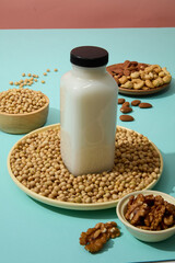 Wall Mural - A ceramic dish containing soybeans with a milk bottle without label placed on. Different types of nuts displayed on another dish. Soybeans contain a high-quality protein