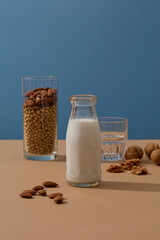 Wall Mural - Fresh milk bottle with empty label displayed with different types of nuts. Soy-based skincare products are a common part of Asian men and women’s daily routines