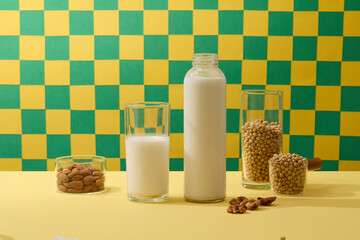 Wall Mural - Glass containers of soybeans and almond arranged with a glass and bottle of milk. Organic product advertising with empty label