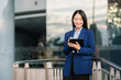 © Nuttapong punna - Young Asian business woman leader entrepreneur, professional manager holding digital tablet computer uon the street in big city