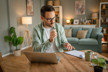 Wall Mural - one man adult caucasian work on laptop at home happy smile