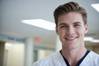 dynamic shot low angle of young age american male nurse in nurse outfit with sly smile looking at camera while standing in modern white american hospital, copy space, design template