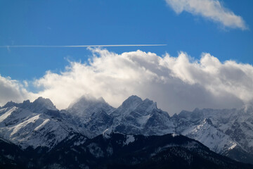 Fototapeta widok na ośnieżone góry i przelatujący samolot nad nimi. szczyty tatr wysokich.