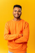 © Vadim Pastuh - Portrait of happy smiley handsome indian man in casual wear posing with arms crossed against orange background, cheerful student guy looks at camera with friendly smile