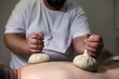 © Alex Vog - Masseur doing spa massage for back man with herbal compresses bag Thai method, close up. Relaxing massage of guy back at salon, health herb massaging. Relax spa massaging concept. Copy ad text space