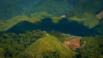 Wall Mural - Green mountain view with a small village on the hill
