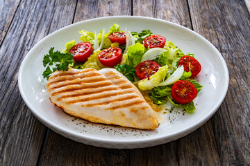 Wall Mural - Grilled chicken breast and fresh vegetables on wooden table
