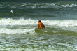 An elderly man bathes in the sea.