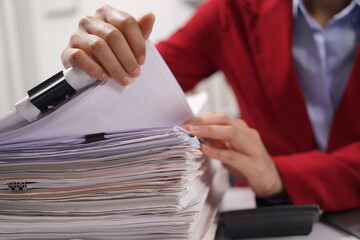 Asian and African office workers trying to feel bored, unhappy and bored working in the office. Business woman. Office worker working with pile of A4 papers. Happy working. Working.