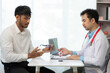 © Witoon - Close-up of an Asian male doctor showing an eyeball model and explaining eye diseases to a male patient in hospital. health care concept