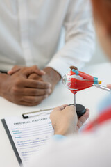 Wall Mural - Close-up of an Asian male doctor showing an eyeball model and explaining eye diseases to a male patient in hospital. health care concept