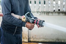 Hand Of Firefighter At Works With Water Cannon