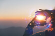 Commercial strategy, planning, and notion of vision. Stunning sunrise in the mountains with a close-up of a young woman making a framing gesture. A woman shooting the dawn