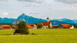 Alpine summer view with a church and the alps in the background near Eisenberg, Ostallgaeu, Bavaria, Germany