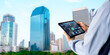© panuwat - Smart Building management system(BMS) concept.Engineer Hands using digital tablet with Building Management Software on blurred modern office building as background