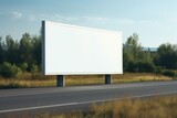 Fototapeta Na ścianę - blank billboard beside a road surrounded by greenery and hills in the background